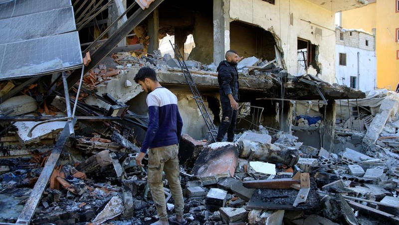 Orang-orang berdiri di atas reruntuhan bangunan yang rusak, di desa Akbiyeh di selatan Lebanon, di tengah permusuhan lintas perbatasan antara Hizbullah dan pasukan Israel, Lebanon, 24 September 2024. (REUTERS/Stringer)