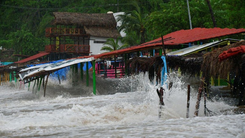 Ombak menerjang restoran-restoran di pantai saat Badai Tropis John bersiap menjadi badai lagi, menerjang kembali masyarakat di sepanjang pantai Pasifik, di Acapulco, Meksiko, 25 September 2024. (REUTERS/Javier Verdin)