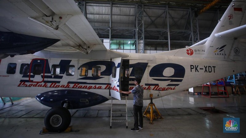 Petugas memeriksa pesawat N-219 Nurtanio yang berada di Hanggar PT Dirgantara Indonesia, Bandung, Jawa Barat, Jumat (27/9/2024). (CNBC Indonesia/Faisal Rahman)