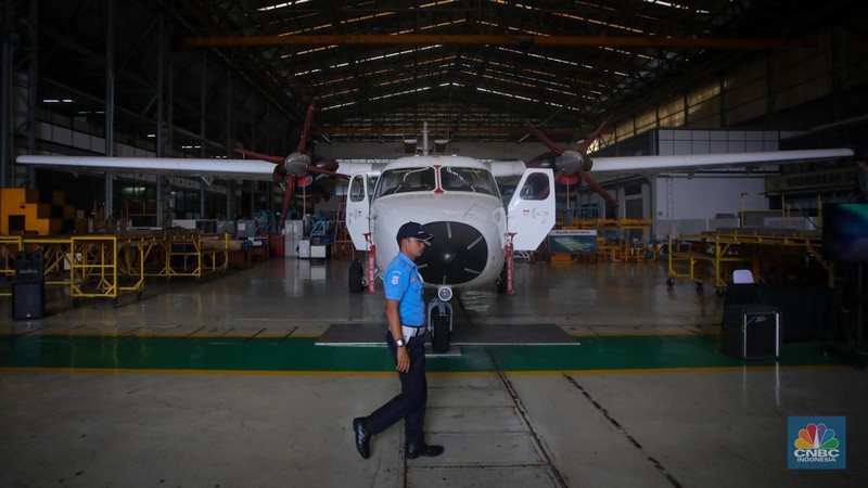 Petugas memeriksa pesawat N-219 Nurtanio yang berada di Hanggar PT Dirgantara Indonesia, Bandung, Jawa Barat, Jumat (27/9/2024). (CNBC Indonesia/Faisal Rahman)