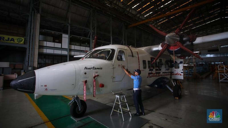 Petugas memeriksa pesawat N-219 Nurtanio yang berada di Hanggar PT Dirgantara Indonesia, Bandung, Jawa Barat, Jumat (27/9/2024). (CNBC Indonesia/Faisal Rahman)