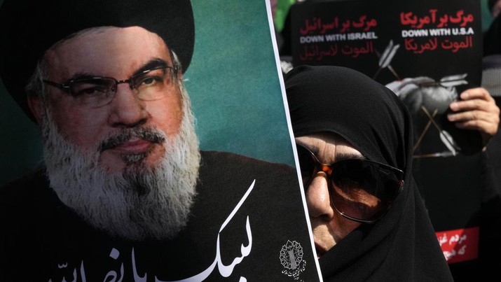 Seorang jamaah Iran mengangkat poster pemimpin Hizbullah Sayyed Hassan Nasrallah. (AP Photo/Vahid Salemi)