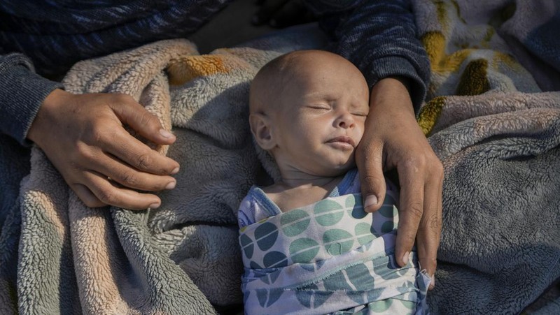 A family sleep on the ground in Beirut's corniche area after fleeing the Israeli airstrikes in the southern suburbs of Dahiyeh, Sunday, Sept. 29, 2024. (AP Photo/Bilal Hussein)