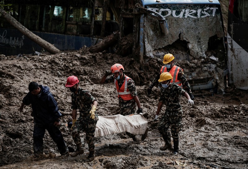 SENSITIVE MATERIAL. THIS IMAGE MAY OFFEND OR DISTURB    Rescue personnel work to retrieve a body recovered from a debris of a passenger bus after a landslide triggered by heavy rainfall struck passenger vehicles passing by the Tribhuwan Highway in Dhading, Nepal, September 29, 2024. REUTERS/Navesh Chitrakar