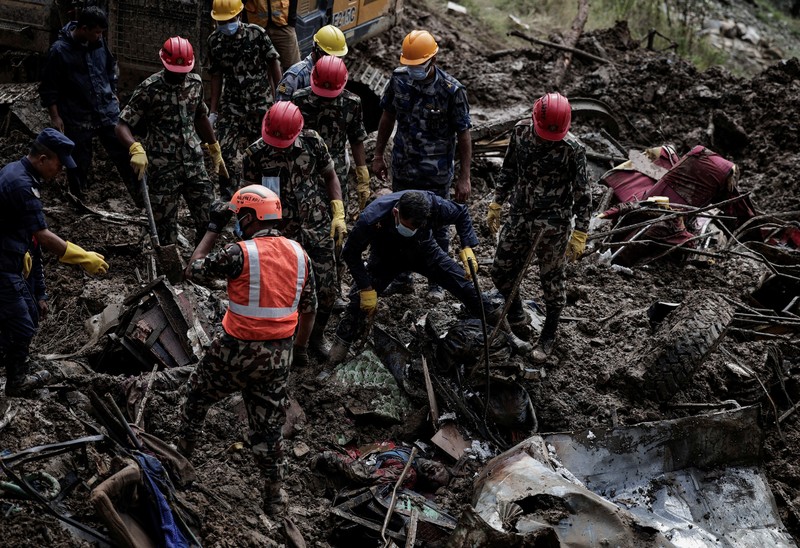 ASIA-WEATHER/NEPAL SENSITIVE MATERIAL. THIS IMAGE MAY OFFEND OR DISTURB Rescue personnel work to retrieve a body recovered from a debris of a passenger bus after a landslide triggered by heavy rainfall struck passenger vehicles passing by the Tribhuwan Highway in Dhading, Nepal, September 29, 2024. REUTERS/Navesh Chitrakar