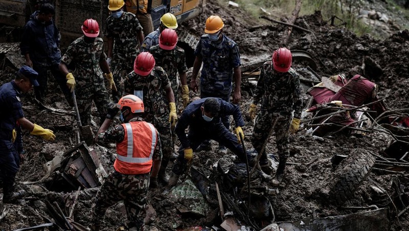 SENSITIVE MATERIAL. THIS IMAGE MAY OFFEND OR DISTURB    Rescue personnel work to retrieve a body recovered from a debris of a passenger bus after a landslide triggered by heavy rainfall struck passenger vehicles passing by the Tribhuwan Highway in Dhading, Nepal, September 29, 2024. REUTERS/Navesh Chitrakar