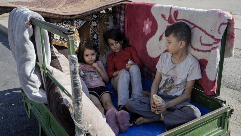 A family sleep on the ground in Beirut's corniche area after fleeing the Israeli airstrikes in the southern suburbs of Dahiyeh, Sunday, Sept. 29, 2024. (AP Photo/Bilal Hussein)