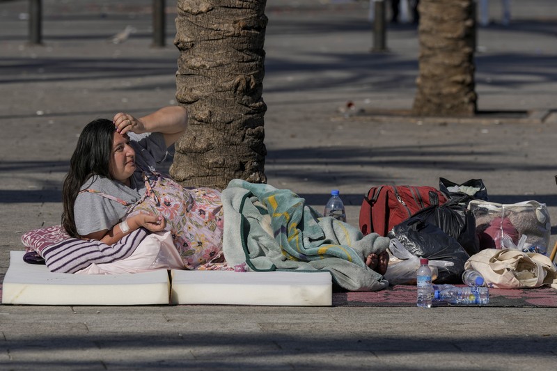 A family sleep on the ground in Beirut's corniche area after fleeing the Israeli airstrikes in the southern suburbs of Dahiyeh, Sunday, Sept. 29, 2024. (AP Photo/Bilal Hussein)