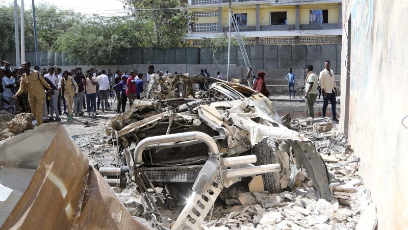 Somali security officers guard residents from the wreckage of a car at the scene of an explosion on a bomb-rigged car that was parked on a road near the National Theatre in Hamarweyne district of Mogadishu, Somalia September 28, 2024. REUTERS/Feisal Omar