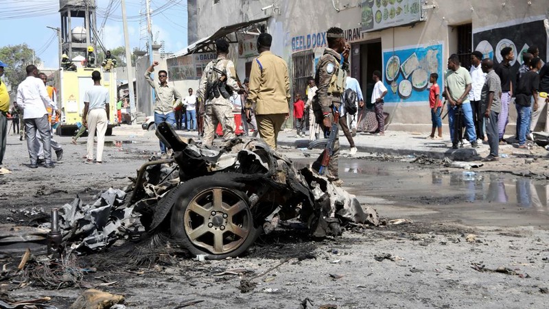 Somali security officers guard residents from the wreckage of a car at the scene of an explosion on a bomb-rigged car that was parked on a road near the National Theatre in Hamarweyne district of Mogadishu, Somalia September 28, 2024. REUTERS/Feisal Omar