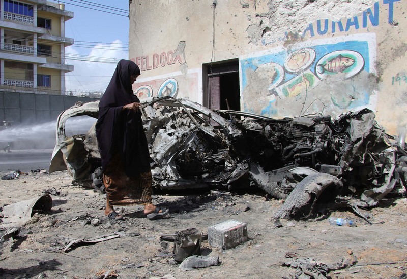 SOMALIA-SECURITY/ Somali security officers guard residents from the wreckage of a car at the scene of an explosion on a bomb-rigged car that was parked on a road near the National Theatre in Hamarweyne district of Mogadishu, Somalia September 28, 2024. REUTERS/Feisal Omar