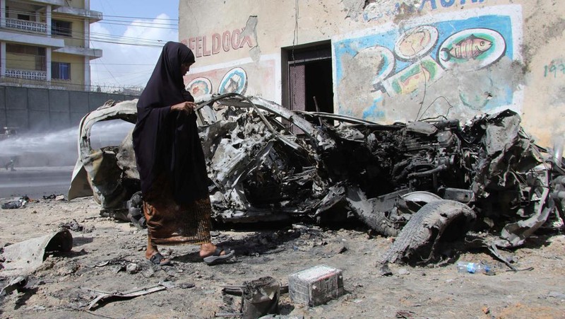 Somali security officers guard residents from the wreckage of a car at the scene of an explosion on a bomb-rigged car that was parked on a road near the National Theatre in Hamarweyne district of Mogadishu, Somalia September 28, 2024. REUTERS/Feisal Omar