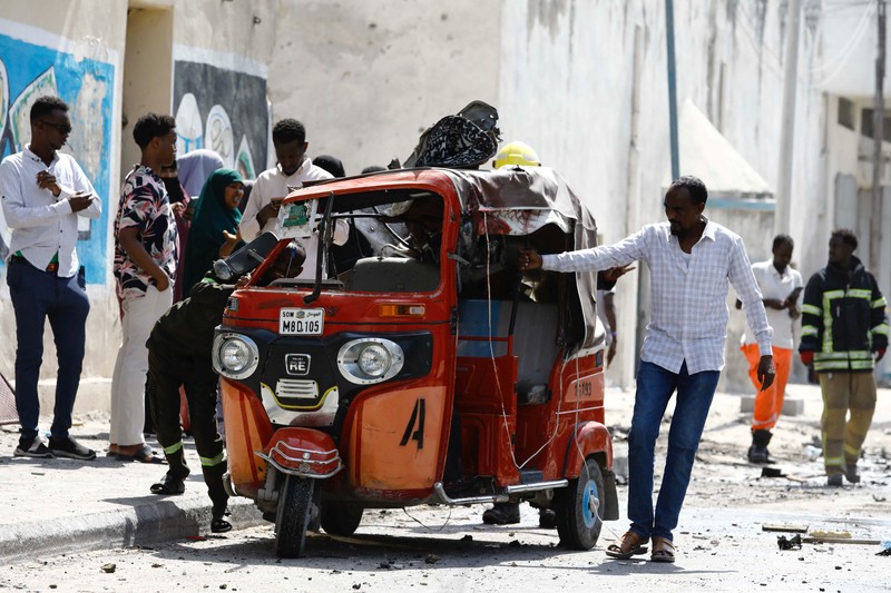 Somali security officers guard residents from the wreckage of a car at the scene of an explosion on a bomb-rigged car that was parked on a road near the National Theatre in Hamarweyne district of Mogadishu, Somalia September 28, 2024. REUTERS/Feisal Omar