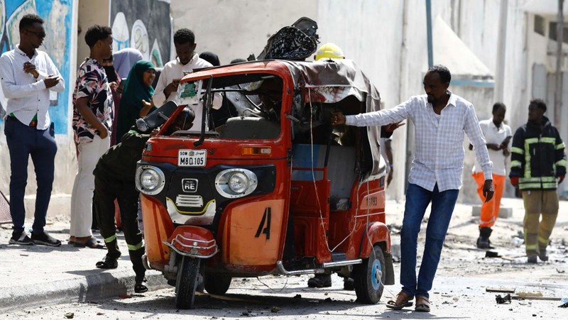 Somali security officers guard residents from the wreckage of a car at the scene of an explosion on a bomb-rigged car that was parked on a road near the National Theatre in Hamarweyne district of Mogadishu, Somalia September 28, 2024. REUTERS/Feisal Omar