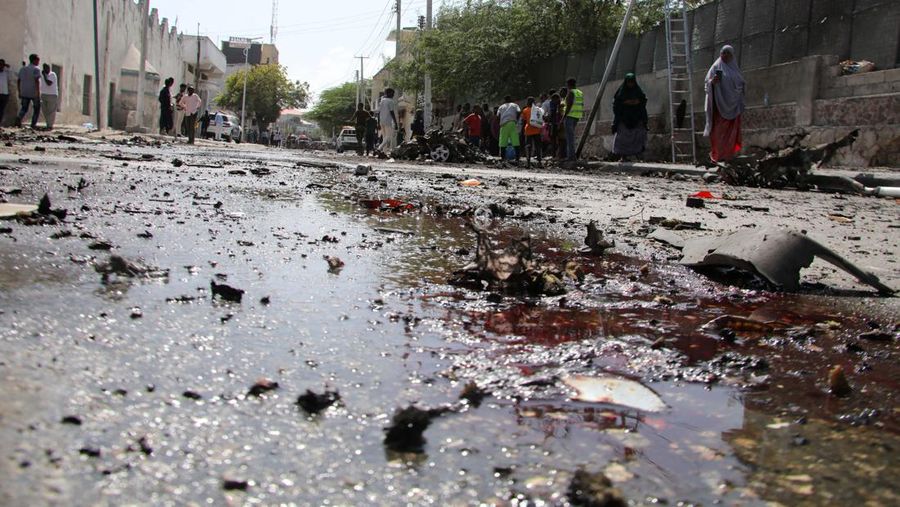 Somali security officers guard residents from the wreckage of a car at the scene of an explosion on a bomb-rigged car that was parked on a road near the National Theatre in Hamarweyne district of Mogadishu, Somalia September 28, 2024. REUTERS/Feisal Omar