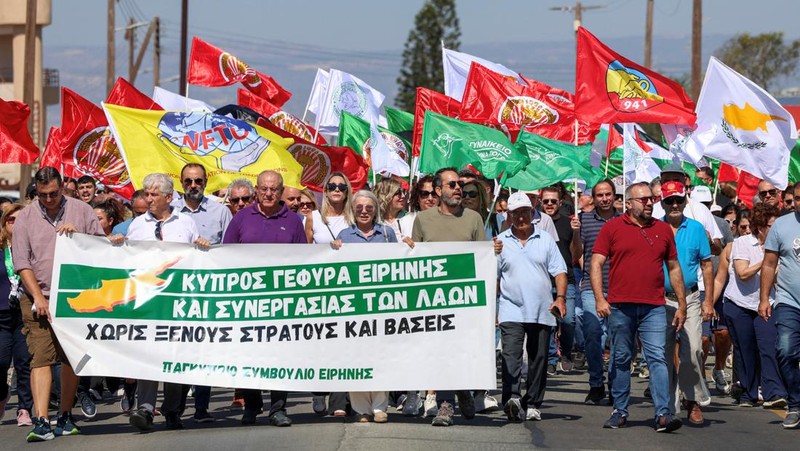 Muslim Syiah Pakistan membawa bendera saat memprotes pembunuhan pemimpin Hizbullah Lebanon Sayyed Hassan Nasrallah dalam serangan udara Israel di Beirut, dengan kontainer pengiriman yang digunakan untuk memblokir area menuju Konsulat AS di Karachi, Pakistan, 29 September 2024. (REUTERS/Imran Ali)