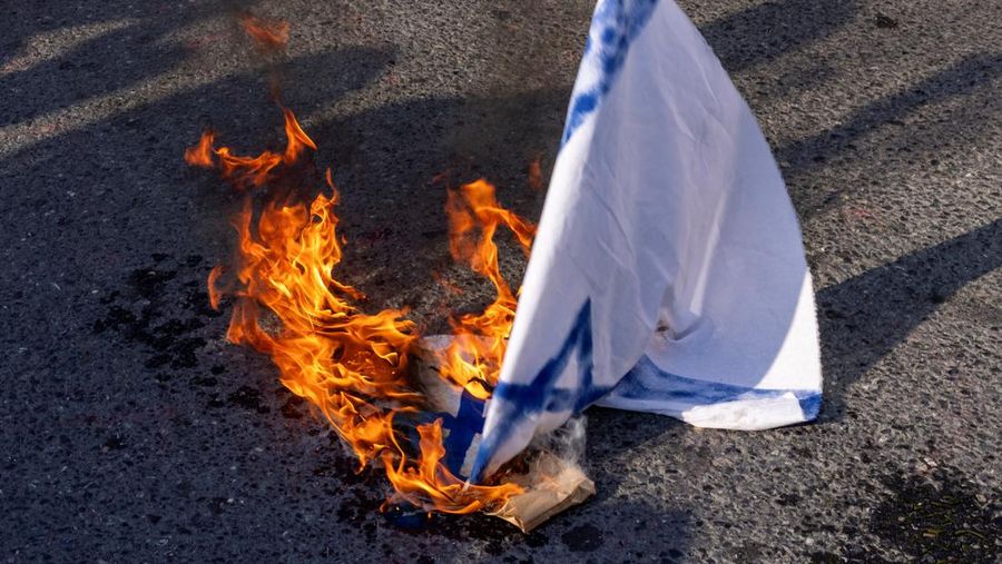 Bendera nasional Israel terbakar saat para pengunjuk rasa berdemonstrasi menentang Israel menyusul terbunuhnya pemimpin Hizbullah Lebanon Sayyed Hassan Nasrallah dalam serangan udara Israel di Beirut, dekat Konsulat Israel di Istanbul, Turki, 29 September 2024. (REUTERS/Umit Bektas)
