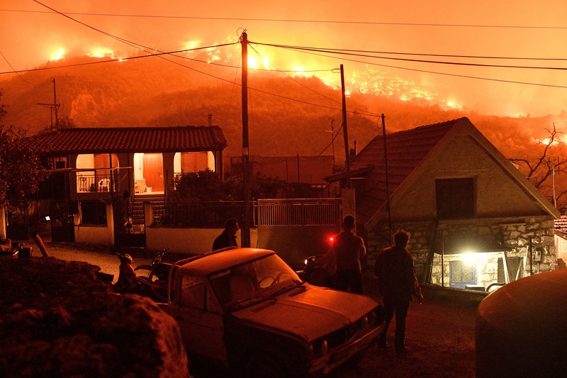 Seorang petugas pemadam kebakaran berusaha memadamkan kebakaran hutan yang terjadi di dekat desa Kallithea, dekat Korintus, Yunani, Senin (30/9/2024). (REUTERS/Vassilis Psomas)