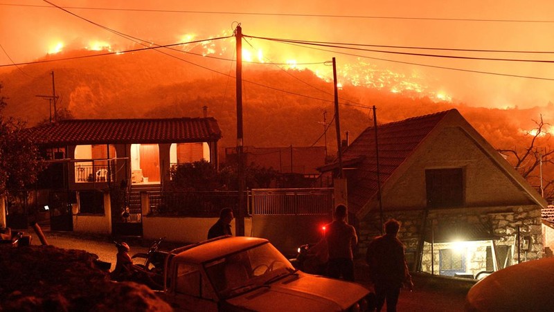 Seorang petugas pemadam kebakaran berusaha memadamkan kebakaran hutan yang terjadi di dekat desa Kallithea, dekat Korintus, Yunani, Senin (30/9/2024). (REUTERS/Vassilis Psomas)