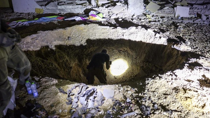 Anggota pasukan penyelamat Israel memeriksa lokasi di mana rudal yang ditembakkan dari Iran ke Israel menghantam gedung sekolah, di Israel tengah, 1 Oktober 2024. (REUTERS/Amir Cohen)