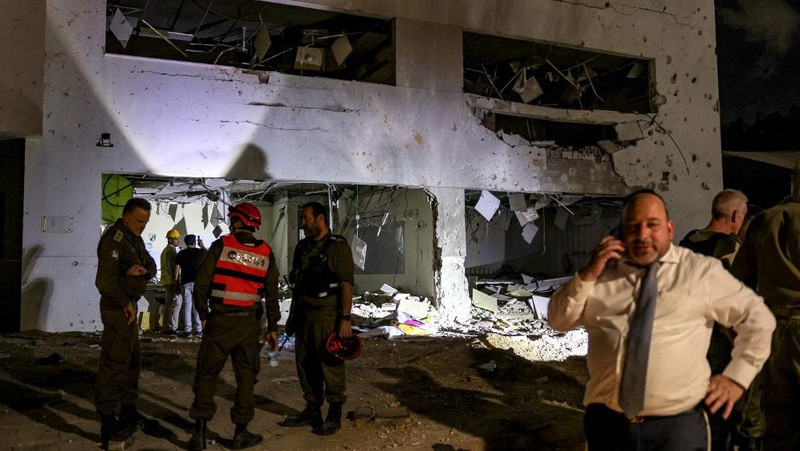 Anggota pasukan penyelamat Israel memeriksa lokasi di mana rudal yang ditembakkan dari Iran ke Israel menghantam gedung sekolah, di Israel tengah, 1 Oktober 2024. (REUTERS/Amir Cohen)