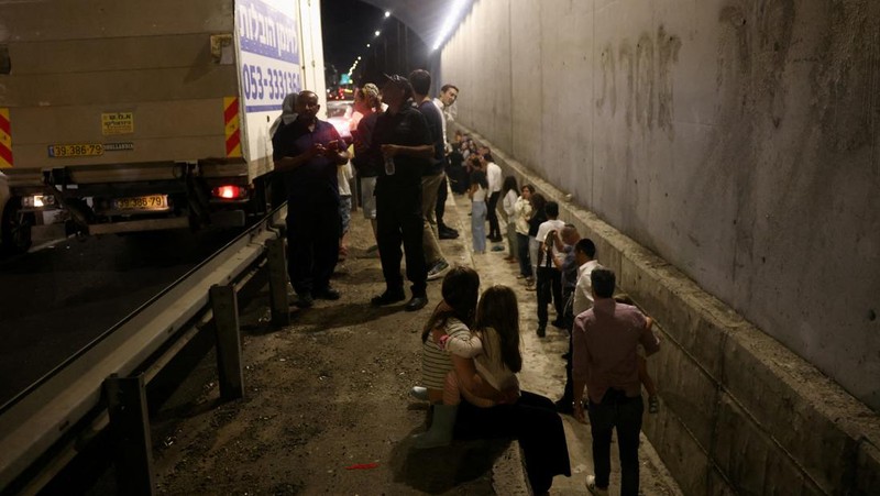 Orang-orang berlari, setelah Iran menembakkan salvo rudal balistik, di tengah permusuhan lintas perbatasan antara Hizbullah dan Israel, dekat Tel Aviv, Israel, 1 Oktober 2024. (REUTERS/Ammar Awad)