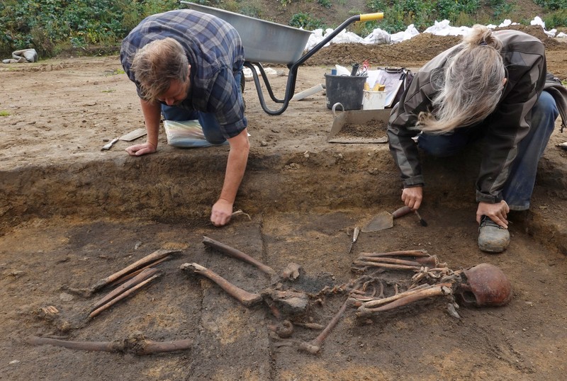 Para arkeolog menggali kerangka di sebuah lubang di situs pemakaman zaman Viking di desa Aasum, Denmark, 25 September 2024. Para arkeolog menggali kerangka di sebuah lubang di situs pemakaman zaman Viking di desa Aasum, Denmark, 25 September 2024. (REUTERS/Tom Little)