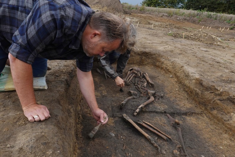 Para arkeolog menggali kerangka di sebuah lubang di situs pemakaman zaman Viking di desa Aasum, Denmark, 25 September 2024. Para arkeolog menggali kerangka di sebuah lubang di situs pemakaman zaman Viking di desa Aasum, Denmark, 25 September 2024. (REUTERS/Tom Little)