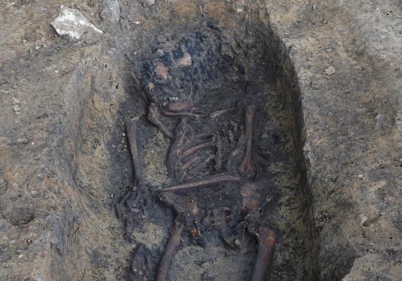 Para arkeolog menggali kerangka di sebuah lubang di situs pemakaman zaman Viking di desa Aasum, Denmark, 25 September 2024. (REUTERS/Tom Little)