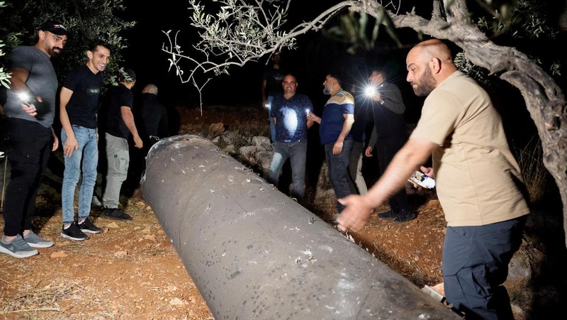 Warga Palestina menyelidiki proyektil, setelah Iran menembakkan salvo rudal balistik, di Tubas, di Tepi Barat yang diduduki Israel, 1 Oktober 2024. (REUTERS/Raneen Sawafta)