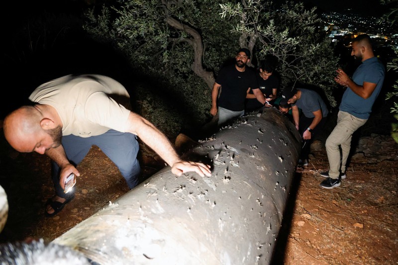 Warga Palestina menyelidiki proyektil, setelah Iran menembakkan salvo rudal balistik, di Tubas, di Tepi Barat yang diduduki Israel, 1 Oktober 2024. (REUTERS/Raneen Sawafta)