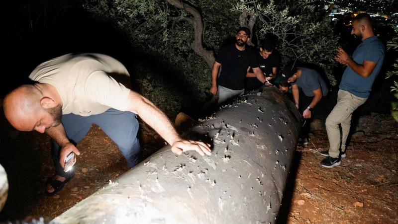 Warga Palestina menyelidiki proyektil, setelah Iran menembakkan salvo rudal balistik, di Tubas, di Tepi Barat yang diduduki Israel, 1 Oktober 2024. (REUTERS/Raneen Sawafta)