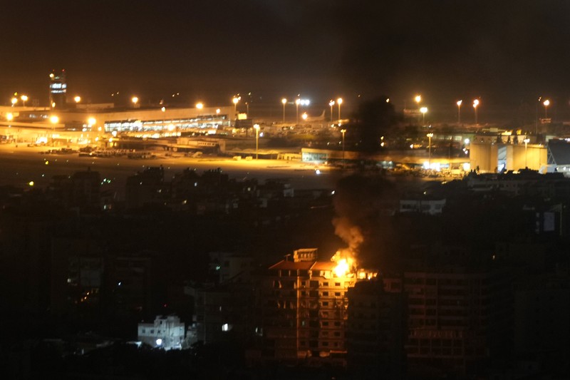 Api dan asap mengepul dari sebuah gedung yang terkena serangan udara Israel di Dahiyeh, sementara Bandara Internasional Rafik Hariri terlihat di latar belakang, di Beirut, Lebanon, Jumat, 4 Oktober 2024. (AP Photo/Hussein Malla) Api dan asap mengepul dari sebuah gedung yang terkena serangan udara Israel di Dahiyeh, sementara Bandara Internasional Rafik Hariri terlihat di latar belakang, di Beirut, Lebanon, Jumat, 4 Oktober 2024. (AP Photo/Hussein Malla)