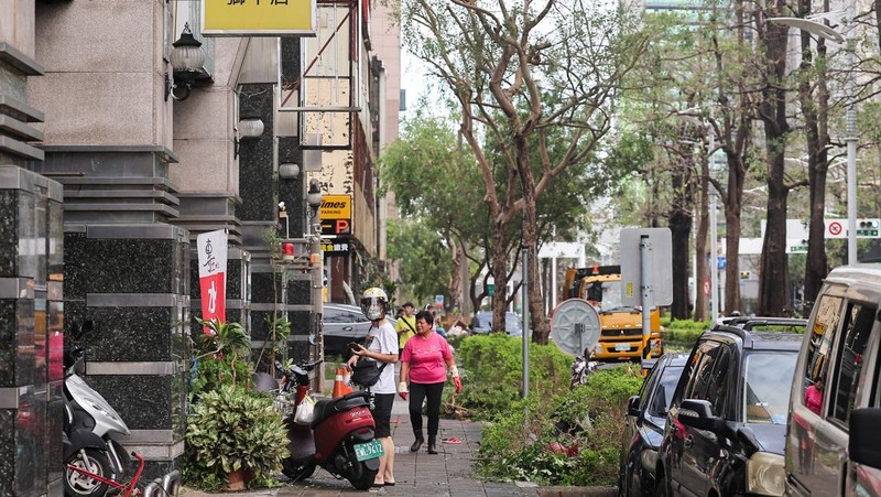 Orang-orang membersihkan jalan setelah Topan Krathon mendarat di Kaohsiung, Taiwan, 4 Oktober 2024. (REUTERS/Ann Wang)