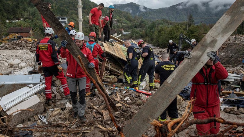 Petugas penyelamat membersihkan puing-puing setelah tanah longsor di desa Donja Jablanica yang banjir, Bosnia dan Herzegovina, 5 Oktober 2024. (REUTERS/Marko Djurica)