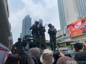 Warga Berfoto di Atas Tank TNI Saat Pawai Alutsista Melintas di Bundaran HI
