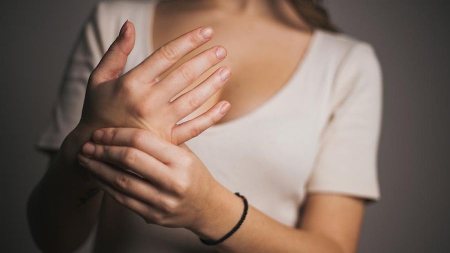 Close-up woman massaging her arthritic hand and wrist, she is suffering from pain and rheumatism