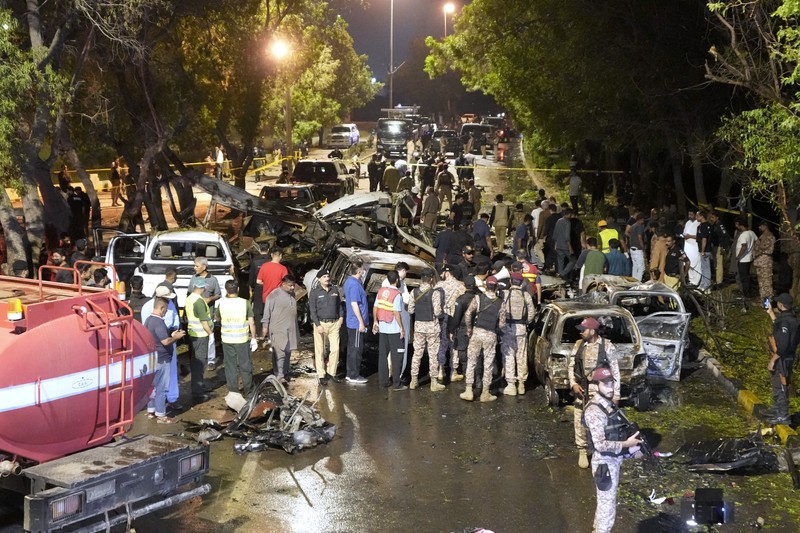 Petugas keamanan memeriksa lokasi ledakan yang menyebabkan cedera dan kerusakan kendaraan di luar bandara Karachi, Pakistan, Senin, 7 Oktober 2024. (AP Photo/Fareed Khan)