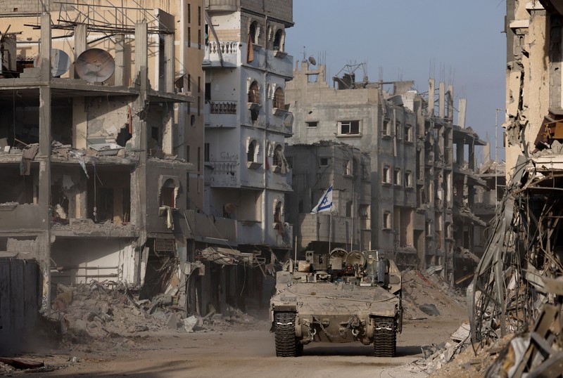 Warga Palestina berjalan melewati rumah-rumah yang hancur, di tengah konflik yang sedang berlangsung antara Israel dan Hamas, di kamp pengungsi Jabalia, di Jalur Gaza utara, 22 Februari 2024. (REUTERS/Mahmoud Issa/File Foto)