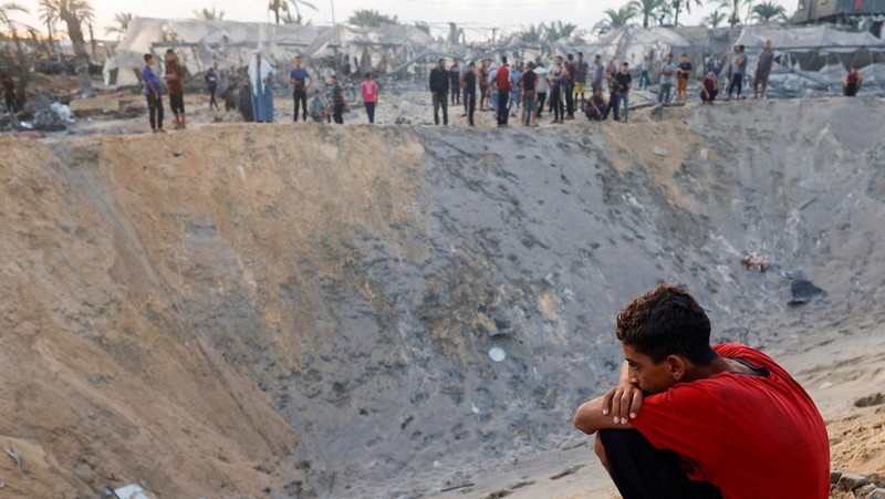 Warga Palestina berjalan melewati rumah-rumah yang hancur, di tengah konflik yang sedang berlangsung antara Israel dan Hamas, di kamp pengungsi Jabalia, di Jalur Gaza utara, 22 Februari 2024. (REUTERS/Mahmoud Issa/File Foto)