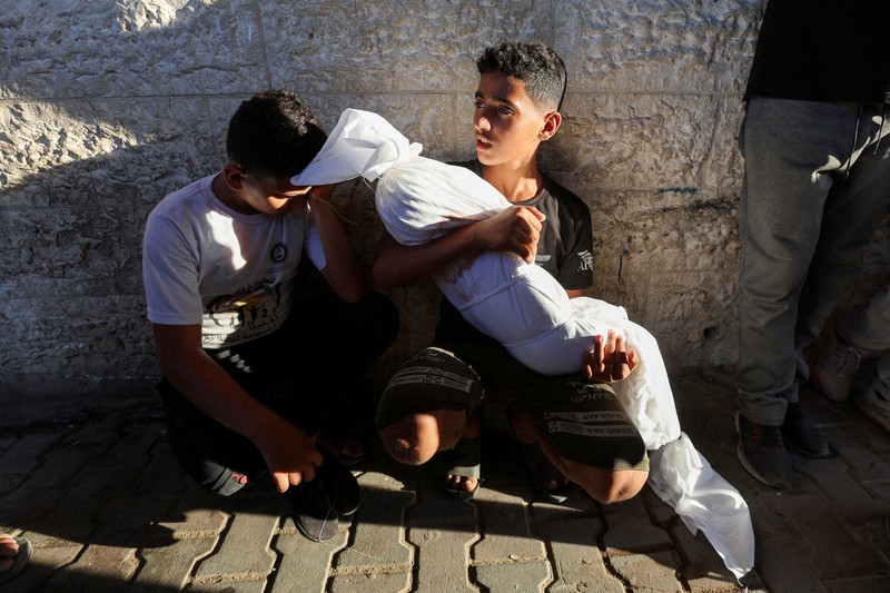Warga Palestina berjalan melewati rumah-rumah yang hancur, di tengah konflik yang sedang berlangsung antara Israel dan Hamas, di kamp pengungsi Jabalia, di Jalur Gaza utara, 22 Februari 2024. (REUTERS/Mahmoud Issa/File Foto)