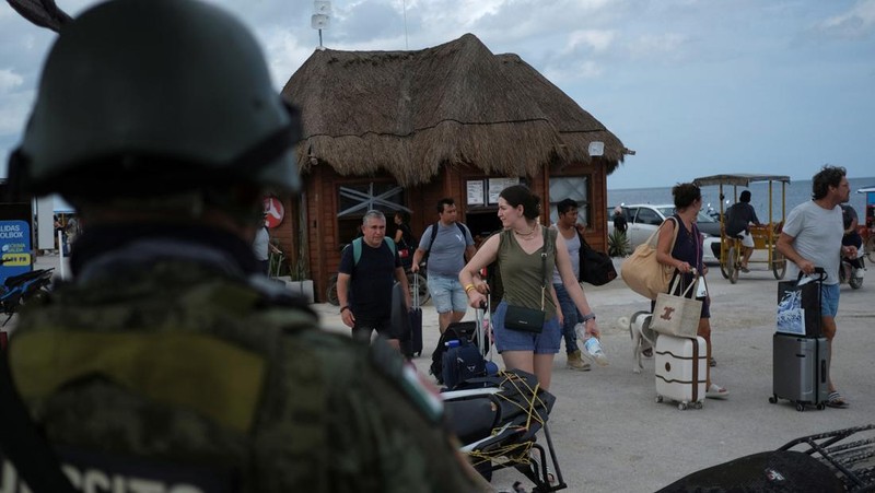 Penduduk dan wisatawan memerlukan panggilan evakuasi sukarela saat Badai Milton bergerak maju, di pulau Holbox, Meksiko, 7 Oktober 2024. (REUTERS/Paola Chiomante)