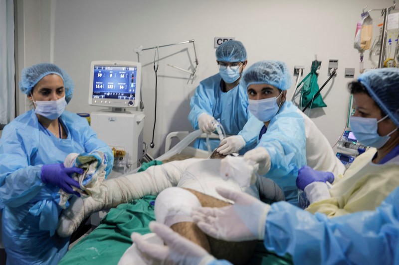 ISRAEL-PALESTINIANS/LEBANON-CASUALITIES Medical staff members attend to a patient, casualty of an airstrike, in the ICU of Geitaoui Hospital burns unit, in Beirut, Lebanon, October 8, 2024. REUTERS/Louisa Gouliamaki