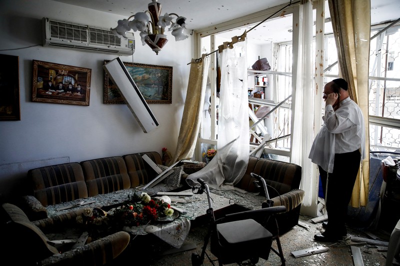 A man stands inside a residential apartment building that was damaged by a rocket fired from Lebanon, amid hostilities between Hezbollah and Israel, in Kiryat Yam, northern Israel, October 8, 2024. REUTERS/Shir Torem     TPX IMAGES OF THE DAY