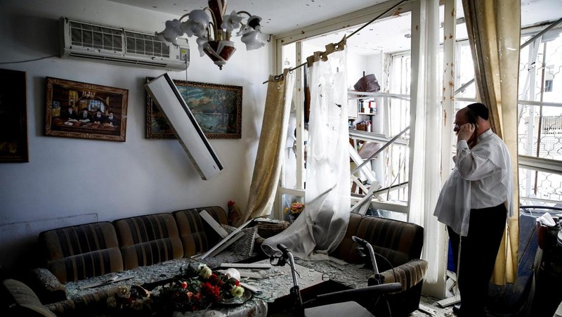 A man stands inside a residential apartment building that was damaged by a rocket fired from Lebanon, amid hostilities between Hezbollah and Israel, in Kiryat Yam, northern Israel, October 8, 2024. REUTERS/Shir Torem     TPX IMAGES OF THE DAY