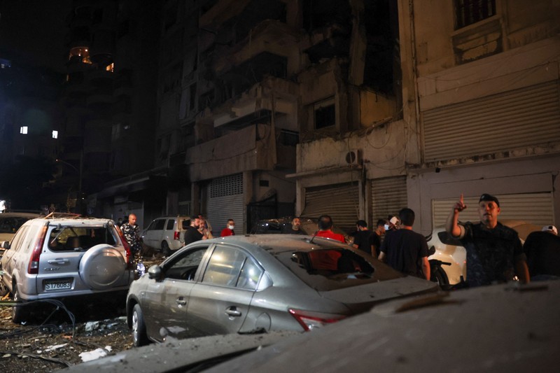 ISRAEL-PALESTINIANS/LEBANON-STRIKE-HEZBOLLAH A building stands on the street while smoke raises, after an Israeli air strike, amid ongoing hostilities between Hezbollah and Israeli forces, in Beirut, Lebanon, October 10, 2024. REUTERS/Louisa Gouliamaki