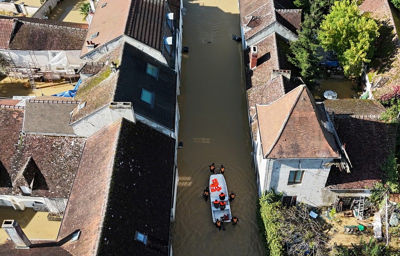 Petugas pemadam kebakaran Prancis berjalan dengan perahu di jalan yang banjir untuk mengevakuasi penduduk di Crecy-la-Chapelle, departemen Seine-et-Marne, setelah hujan lebat dan badai Kirk menyebabkan banjir di negara itu, Prancis, 11 Oktober 2024. (REUTERS/Abdul Saboor)