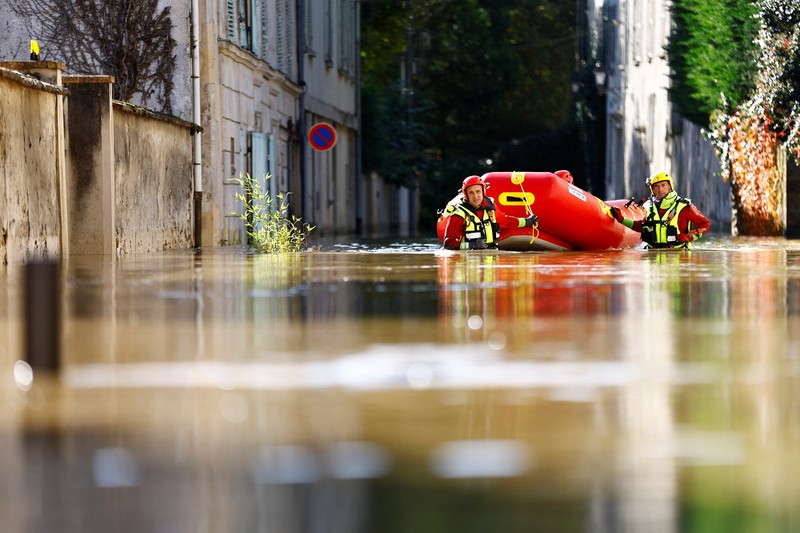Petugas pemadam kebakaran Prancis berjalan dengan perahu di jalan yang banjir untuk mengevakuasi penduduk di Crecy-la-Chapelle, departemen Seine-et-Marne, setelah hujan lebat dan badai Kirk menyebabkan banjir di negara itu, Prancis, 11 Oktober 2024. (REUTERS/Abdul Saboor)