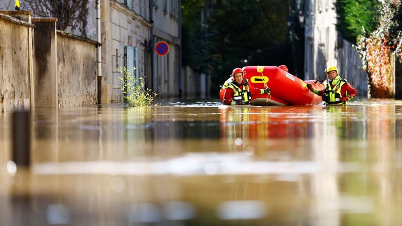 Petugas pemadam kebakaran Prancis berjalan dengan perahu di jalan yang banjir untuk mengevakuasi penduduk di Crecy-la-Chapelle, departemen Seine-et-Marne, setelah hujan lebat dan badai Kirk menyebabkan banjir di negara itu, Prancis, 11 Oktober 2024. (REUTERS/Abdul Saboor)