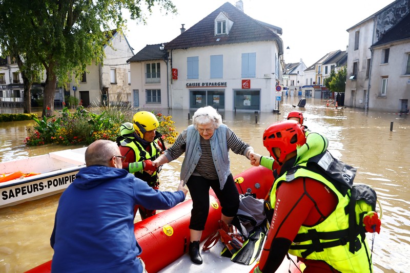 Petugas pemadam kebakaran Prancis berjalan dengan perahu di jalan yang banjir untuk mengevakuasi penduduk di Crecy-la-Chapelle, departemen Seine-et-Marne, setelah hujan lebat dan badai Kirk menyebabkan banjir di negara itu, Prancis, 11 Oktober 2024. (REUTERS/Abdul Saboor)